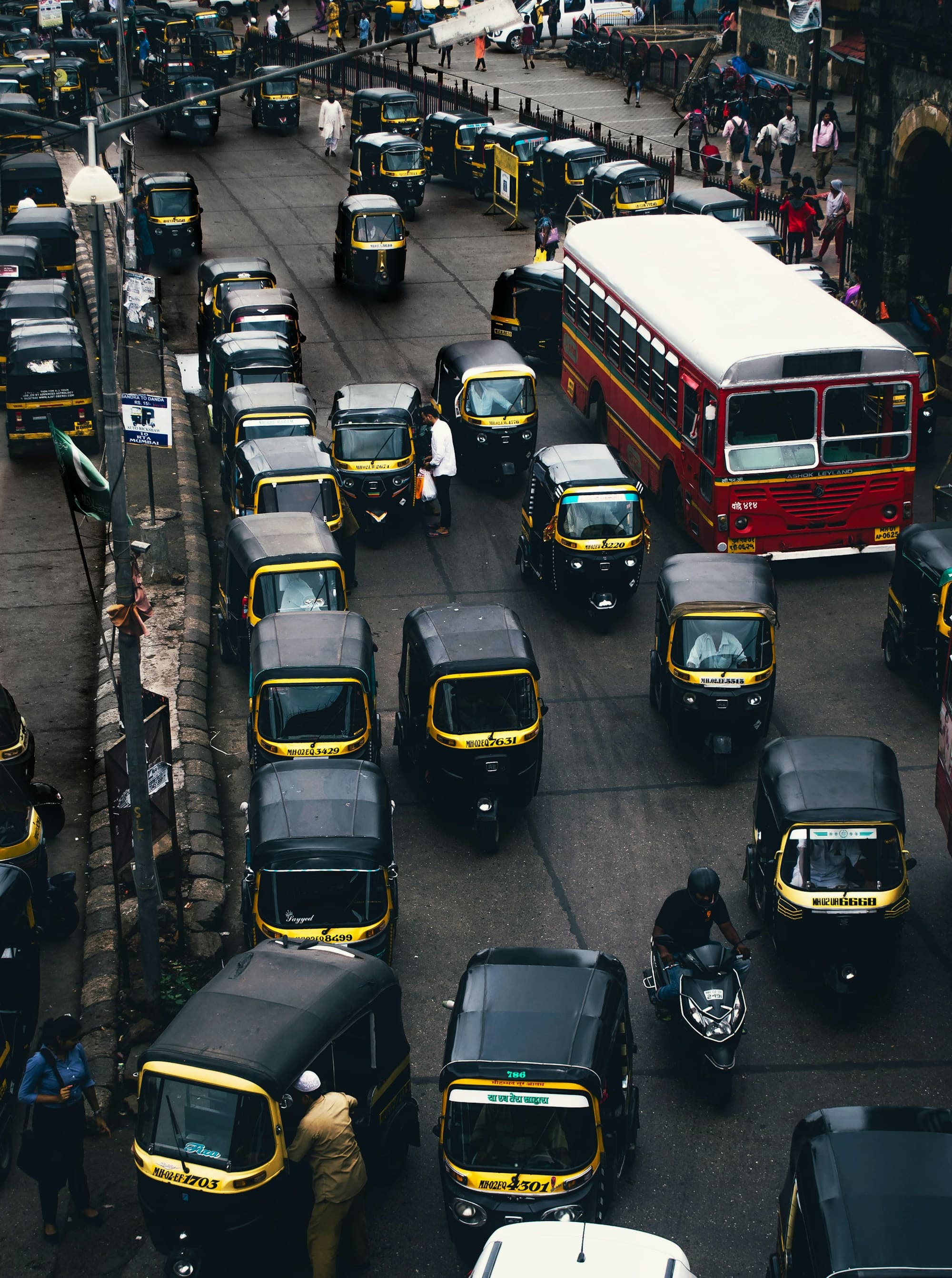 A street packed with black-and-yellow auto-rickshaws in India